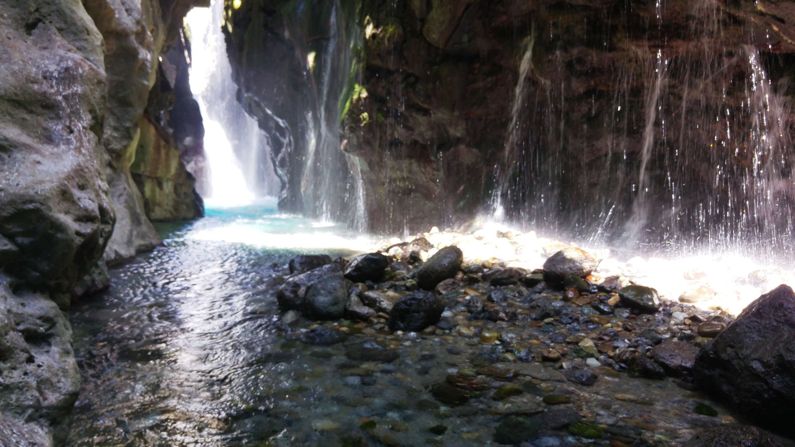 Waterfall curtain and rocky foreground inside Kourtaliotiko Gorge